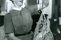 07_District nurse - midwife Catriona MacAskill weighing a baby in North Uist, Scotland, 'he's put on weight!' -c.1959